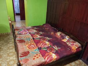 a bed in a room with a bedspread with flowers on it at RAOJI Home Stay in Vālpārai