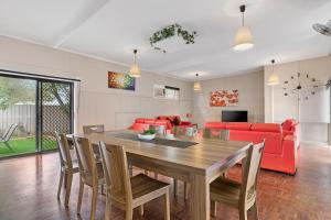 ein Wohnzimmer mit einem Holztisch und Stühlen in der Unterkunft Spacious 4 Bdrms near Murray River, Pet Friendly in Strathmerton