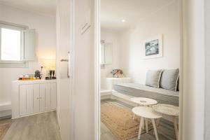 a small white room with a bed and a table at Amoramelia Villas in Imerovigli