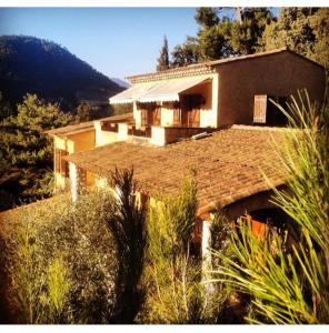 a house with a roof with a mountain in the background at Paradise in Peille