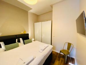 une chambre d'hôtel avec un lit et deux chaises dans l'établissement Villa Anna - Kaiserperle, à Heringsdorf