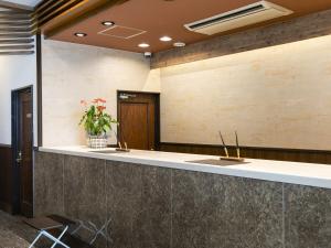 un hall de bureau avec un comptoir de réception et une usine dans l'établissement Hotel Wing International Hitachi, à Hitachi
