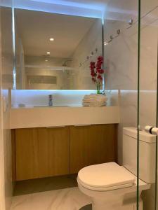 Un baño con inodoro, lavabo y espejo. en Stunning view over Ipanema, 2 BR, en Río de Janeiro