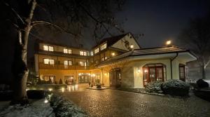 una casa grande por la noche con nieve en el suelo en Hotel Fohlenhof, en Ampfing