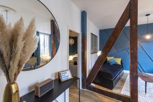 einen Flur mit einem Spiegel und einem Bett in einem Zimmer in der Unterkunft PARENTHESE - Le Vignemale in Lourdes