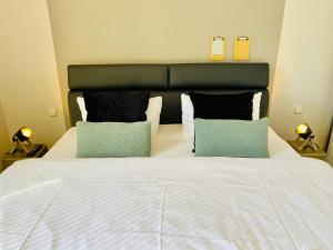 une chambre avec un grand lit blanc avec deux oreillers dans l'établissement Villa Anna - Kaiserperle, à Heringsdorf