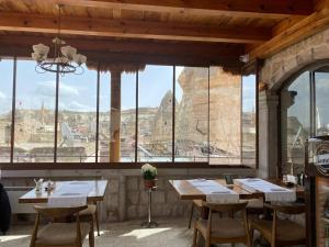 a restaurant with wooden tables and chairs and a view ofartifacts at Aydinli Cave Hotel in Göreme