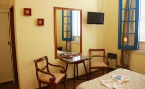 1 dormitorio con cama, mesa y espejo en Hotel El Mirador en Chascomús