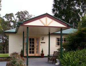 a small white house with a large roof at Snowy river homestead in Newmerella