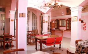 a dining room with red chairs and tables in a building at Hotel El Mirador in Chascomús