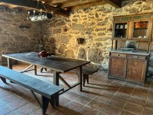 a kitchen with a wooden table and a bench at Casa Lagar de Arume in Ponteareas