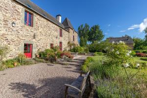 a stone building with a bench in front of it at Manoir le Courtillon in Le Pont Réan