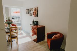 ein Wohnzimmer mit einem TV, einem Tisch und Stühlen in der Unterkunft Stadt Land Fluss New Apartments by Zollhaus in Forchheim