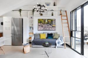uma sala de estar com um sofá e um frigorífico em Haivy Land by HolyGuest em Tel Aviv