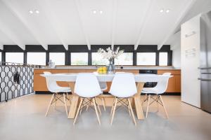 een keuken en eetkamer met een witte tafel en witte stoelen bij Haivy Land by HolyGuest in Tel Aviv