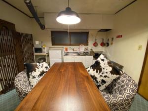 a kitchen with a wooden table and two chairs at 札幌ドーム前ハウス Sapporodome front house in Sapporo