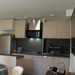 - une cuisine avec des placards blancs et gris et un évier dans l'établissement IZERSKA ZATOKA, à Stara Kamienica