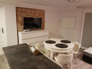 Il comprend un salon doté d'une table blanche et d'une télévision. dans l'établissement IZERSKA ZATOKA, à Stara Kamienica