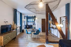 uma sala de estar com uma mesa e cadeiras azuis em PARENTHESE - Le Vignemale em Lourdes