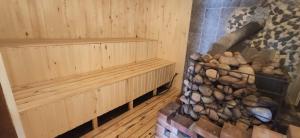 a sauna with wooden cabinets and a stack of logs at Skaistkrasti in Tīnūži