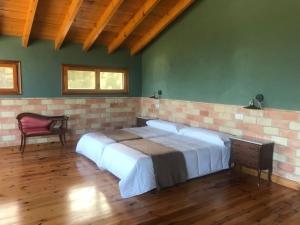 Cama grande en habitación con pared de ladrillo en MASIA MAS DE LA CREU, en Valderrobres