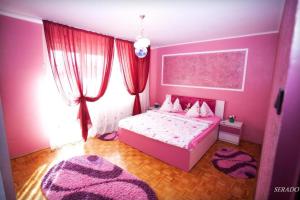 百樂費利克斯的住宿－Apartamente DELUXE Serado，粉红色的卧室设有床和窗户