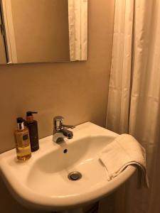 a white sink in a bathroom with a mirror at Hotell Kaprifol in Hunnebostrand