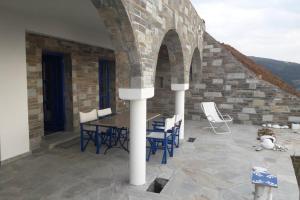 een patio met een tafel en stoelen in een gebouw bij Ferienwohnung Castello Sebastian in Argalasti