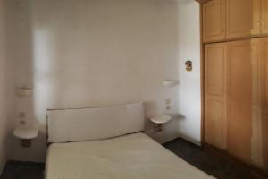 a small bedroom with a bed and a wooden door at Ferienwohnung Castello Sebastian in Argalasti