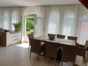 a dining room with a table and chairs at Nádliget Vendégház in Ábrahámhegy