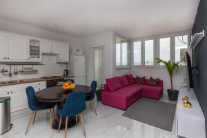 sala de estar con sofá púrpura y mesa en LEILANI -Stunning view apartment near the center! en Split