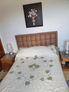 a bedroom with a bed with a bedspread with flowers on it at Appartement avec vue panoramique in Tetouan