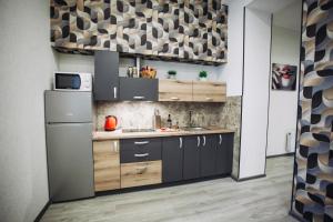 a kitchen with a sink and a refrigerator at LOFT de luxe apartments in Vinnytsya