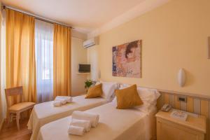 a hotel room with two beds and a window at Hotel Massimo in Marina di Cecina