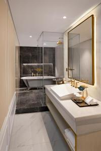 a bathroom with a sink and a bath tub at Sutasoma Hotel in Jakarta