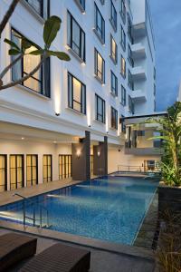 a swimming pool in front of a building at Sutasoma Hotel in Jakarta