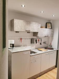 a kitchen with white counters and white appliances at Die Birke in Bremen