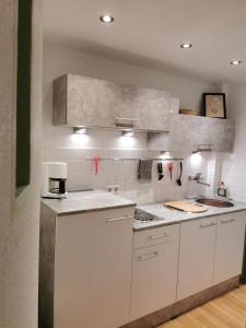 eine Küche mit weißen Arbeitsflächen und weißen Geräten in der Unterkunft Die Birke in Bremen