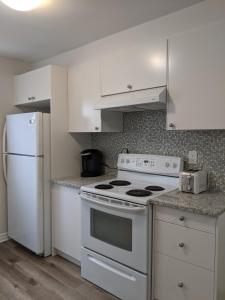 cocina con electrodomésticos blancos y nevera blanca en 3 BDR appartement,WiFI,Netflix free parking en Montreal