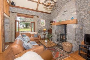 a living room with a couch and a stone fireplace at Cae'r Beili in Llandovery