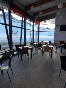 a restaurant with tables and chairs and a view of the ocean at Hostal Pico Agujas in San Isidro