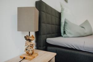 a lamp on a table next to a bed at Stadt Land Fluss first Apartments by Zollhaus in Forchheim