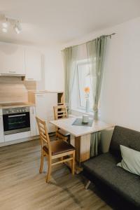 uma cozinha e sala de estar com uma mesa e um sofá em Stadt Land Fluss first Apartments by Zollhaus em Forchheim