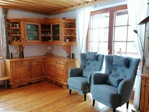 a living room with two chairs and a wooden cabinet at Almhaus Kärnten Flattnitz in Flattnitz