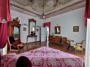 Le Foglie Di Acanto في لوتشرا: غرفة نوم بسرير وردي وطاولة وكراسي