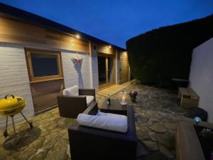 a patio with a couch and a table and a building at Littlebeads in Chichester +3 photos