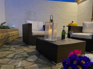a patio with two chairs and a table with a bottle of wine at Littlebeads in Chichester