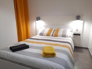 um quarto com uma cama com uma toalha amarela em kérentrée - Appartement en centre ville avec terrasse et parking privé em Pont-lʼAbbé