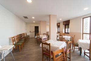 un comedor con mesas y sillas blancas y una habitación con mesas y sillas blancas. en Hostal Pico Agujas, en San Isidro