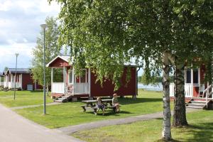 two people sitting on a bench in front of a cabin at Malungs Camping in Malung